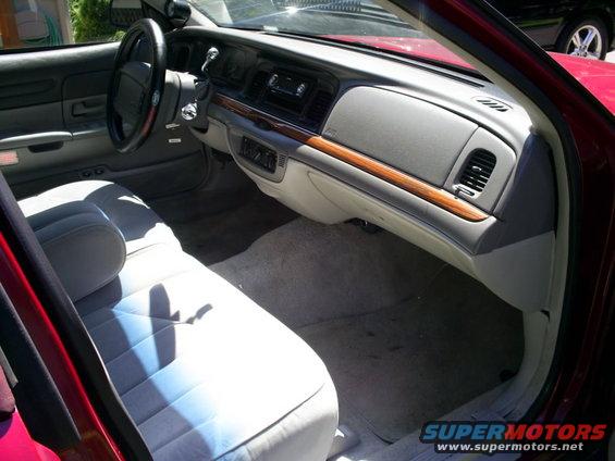 1995 Ford Crown Victoria interior with light grey cloth seats, wood trim dashboard, and black steering wheel