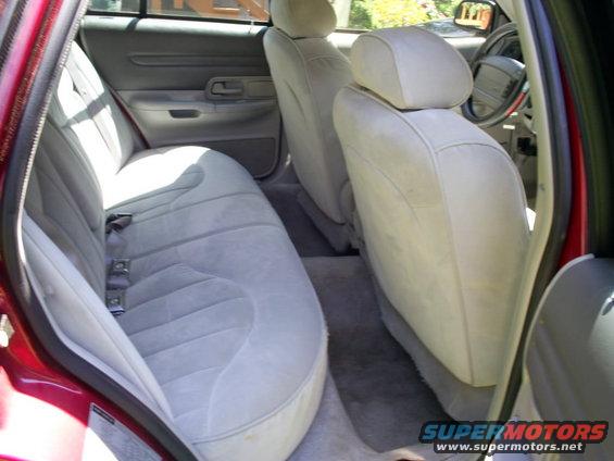 Interior view of a red car showing light gray cloth seats and dashboard