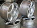 1994 Ford Probe - A set of four silver alloy wheels, each a five-spoke design, are stacked and displayed.