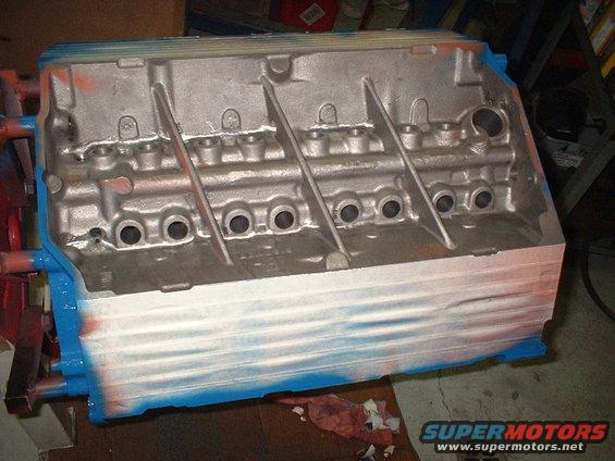 Engine block with blue and white spray paint, showing cylinder bores and internal structure