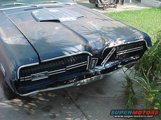 The hood was dented right in the center and the driver side grille was busted. Fortunately the GT-E grille bars were all there and restorable.