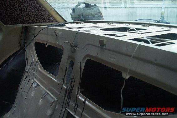 Car interior stripped down, showing metal frame and leopard print headliner