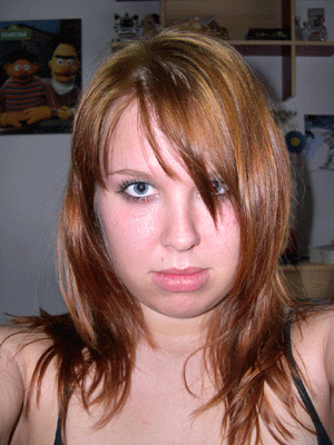 Woman with reddish-brown hair and bangs covering one eye