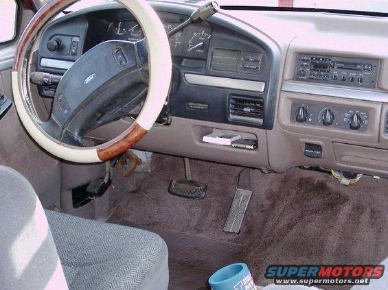 Dashboard and steering wheel of a truck, showing the radio, vents, and pedals. A "Supermotors.net" watermark is visible