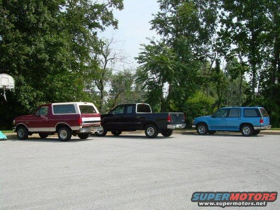Red Bronco, black pickup, and blue SUV parked side-by-side