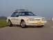 1993 Ford Mustang - A 1993 Ford Mustang police car is parked on the side of a road under a clear sky.
