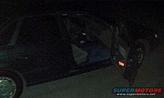 Dark sedan side view, driver's door open