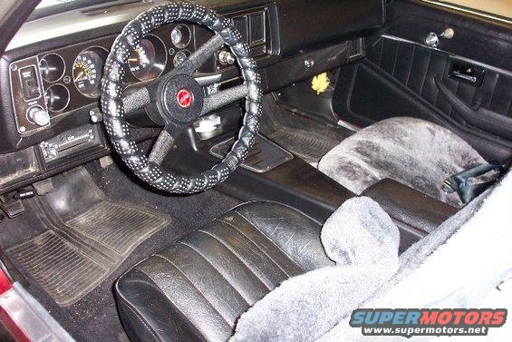 Interior view of a car with a custom steering wheel cover and fuzzy seat covers