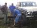 1978 Ford Bronco - A group of men are working to move a large log near a Ford Bronco, possibly for an off-road event.