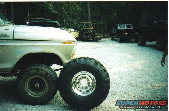 Silver 1973 Ford F-Series truck front fender and large tire, other trucks in background