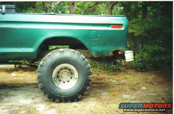 1979 Ford F-250 rear quarter panel, showing rust damage near the bumper mount, and a large off-road tire