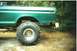 1979 Ford F-250 - Rear view of a 1979 Ford F-250 pickup truck with a large tire and visible rust.