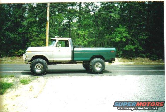 1979 Ford F-250 pickup truck, two-tone white and green, lifted with large tires, parked on the side of a road