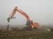 1978 Ford Bronco - An excavator operates in a foggy field, with two people and a dog nearby.