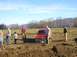 1978 Ford Bronco - A red SUV is stuck in a muddy field with several people observing.