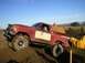 1978 Ford Bronco - Red and white 1978 Ford Bronco modified for off-road use, climbing a dirt embankment.