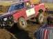 1978 Ford Bronco - 1978 Ford Bronco navigating a muddy off-road course, driver visible.