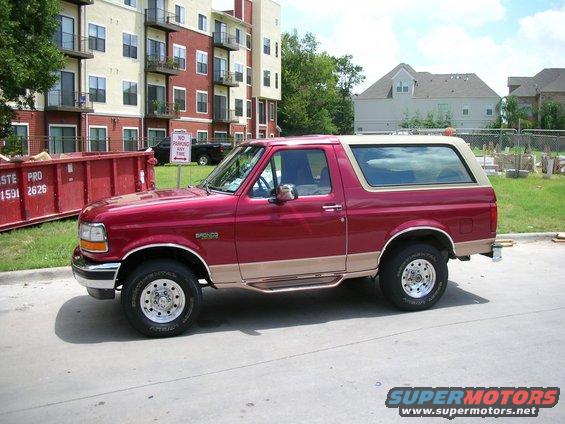 1995 Ford Bronco side view, red with tan trim and removable top