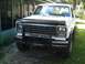 1986 Ford Bronco - This white SUV features a prominent black grille guard and oversized tires, seen from a 3/4 front angle.