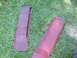 1986 Ford Bronco - Two red car trim pieces lie on the grass, suggesting they are parts from a vehicle.