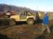 1978 Ford Bronco - A yellow Jeep Wrangler navigates a muddy off-road course, with a red Ford pickup truck visible behind it.