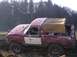 1978 Ford Bronco - A red 1978 Ford Bronco with a tan soft top is seen in a muddy field.