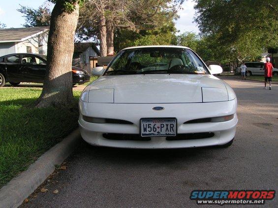 1995 Ford Probe front view parked on street, license plate W56 PXR. Black car and trees visible