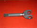 1994 Jeep YJ - A driveshaft yoke with a splined end and U-joint mounting ears is shown against a red textured background.
