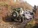 1978 Ford Bronco - A yellow off-road vehicle tackles a challenging muddy trail with other vehicles and people in the background.