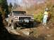 1978 Ford Bronco - A 1978 Ford Bronco navigates a challenging, rocky off-road trail with a bystander observing.
