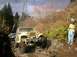 1978 Ford Bronco - A yellow Jeep CJ-5 navigates a rocky trail, with a second vehicle visible in the background.