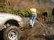 1978 Ford Bronco - Several people are navigating a challenging off-road course with a silver SUV stuck on a rocky incline.