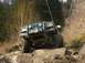 1978 Ford Bronco - This off-road vehicle navigates a challenging rocky path, its front end prominently displayed with a winch and brush guard.