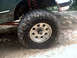 1996 Ford Bronco - This image focuses on the tire and suspension components of an off-road vehicle, suggesting it's built for challenging terrain.