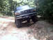 1996 Ford Bronco - This Ford Bronco is navigating a rocky obstacle on a wooded trail.