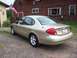 2000 Ford Taurus - Rear view of a 2000 Ford Taurus sedan parked outdoors near a rustic building.