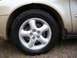 2000 Ford Taurus - A close-up view of a car's wheel and part of the fender. The tire is black and the rim is silver.