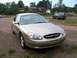 2000 Ford Taurus - A gold 2000 Ford Taurus is parked in a grassy area with houses in the background.