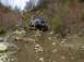 1978 Ford Bronco - A Jeep CJ-7 is shown attempting to traverse a difficult off-road course with steep inclines and loose terrain.