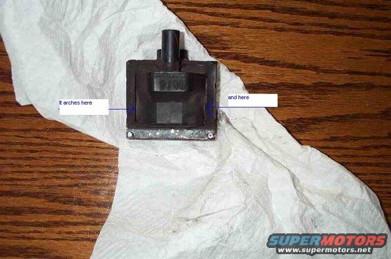Black automotive part with "6100" visible, on white paper towel