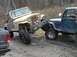 1978 Ford Bronco - Two Jeeps appear to be stuck in a muddy, wooded area, with one vehicle on top of the other.
