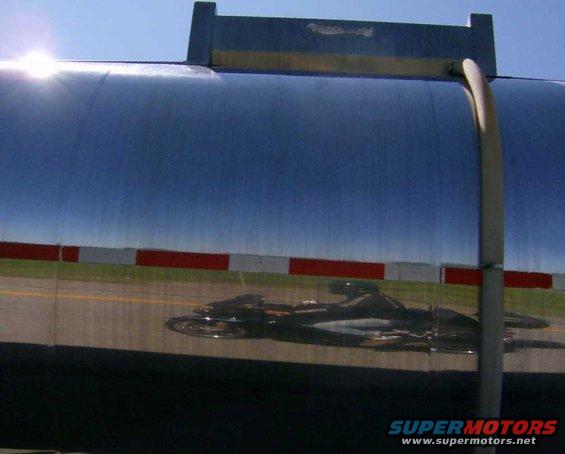 Street sign against a blue sky with a distant train on tracks