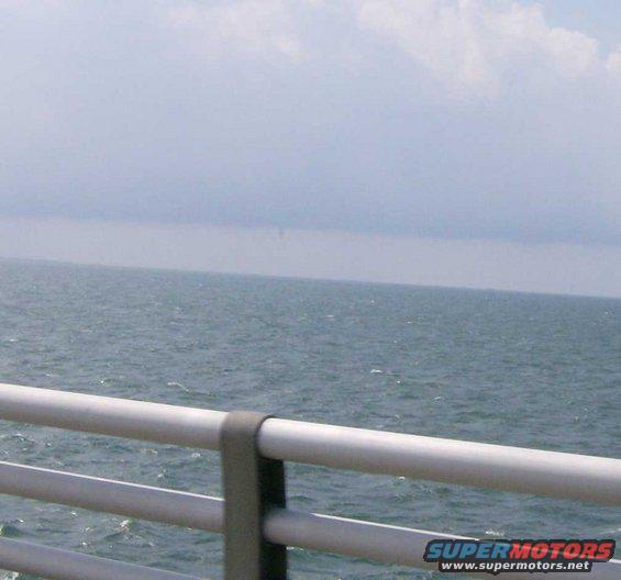 Water and sky seen from a bridge railing