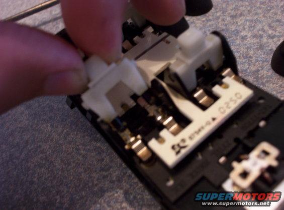 Close-up of a circuit board with white plastic connectors being manipulated by fingers. Text '0250' is visible