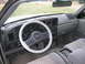 1988 Ford Thunderbird - Interior view of a car, possibly a Ford Thunderbird, with a white steering wheel cover and a fire hydrant visible outside.