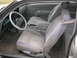 1988 Ford Thunderbird - The interior of a 1988 Ford Thunderbird features cloth seats, a gray dashboard, and a white steering wheel cover.