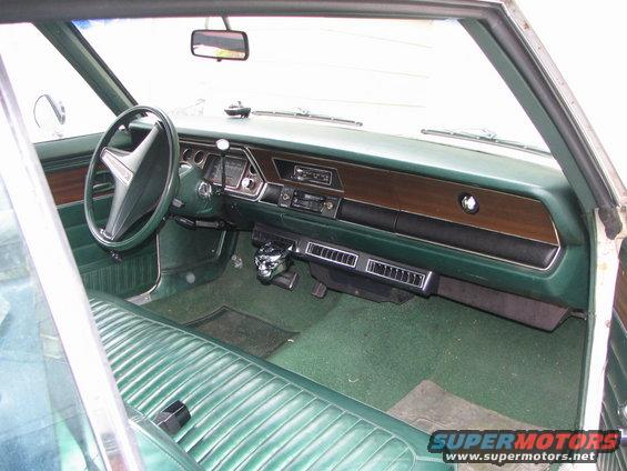 Green vinyl bench seat and dashboard of a 1975 Dodge Dart, viewed from the passenger side