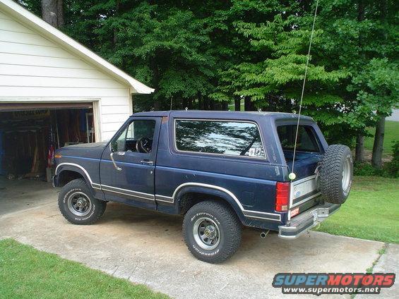 Blue Ford Bronco with spare tire on rear, parked on driveway
