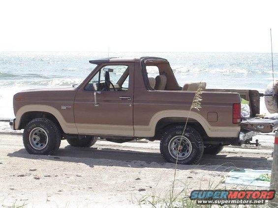 Brown 1985 Ford Bronco side view on beach