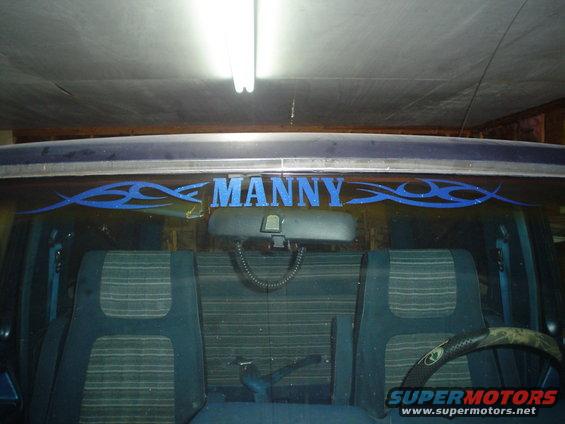 Vehicle interior with blue tribal graphics and "MANNY" text on the rear window